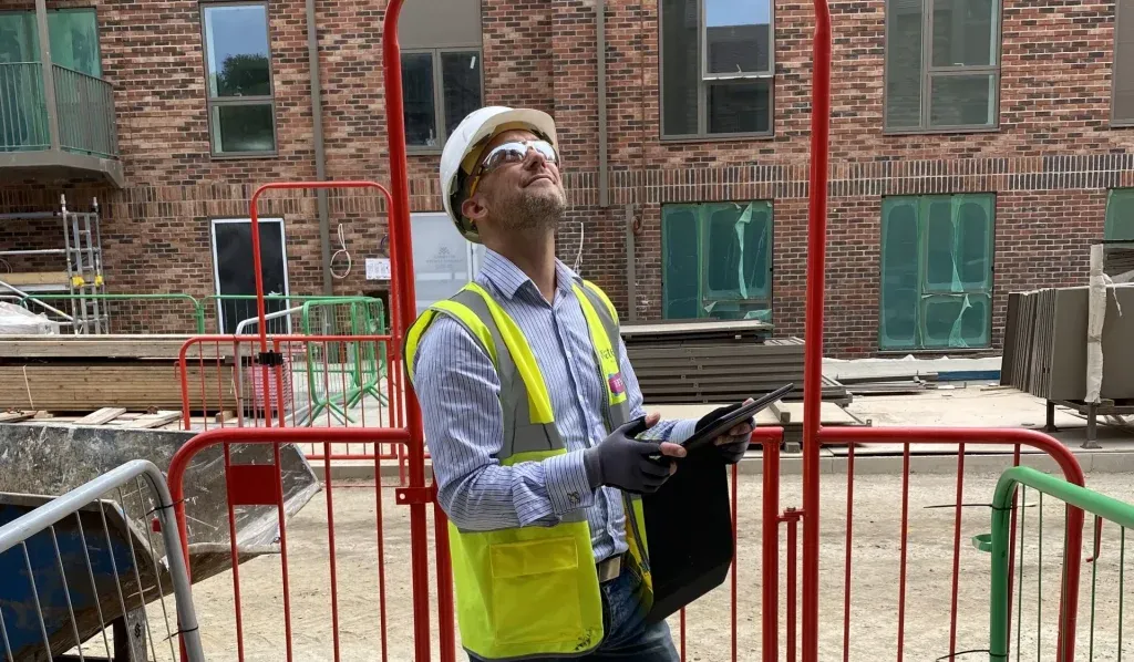 EcoSkye surveyor inspecting the facade of a new brick apartment building on site
