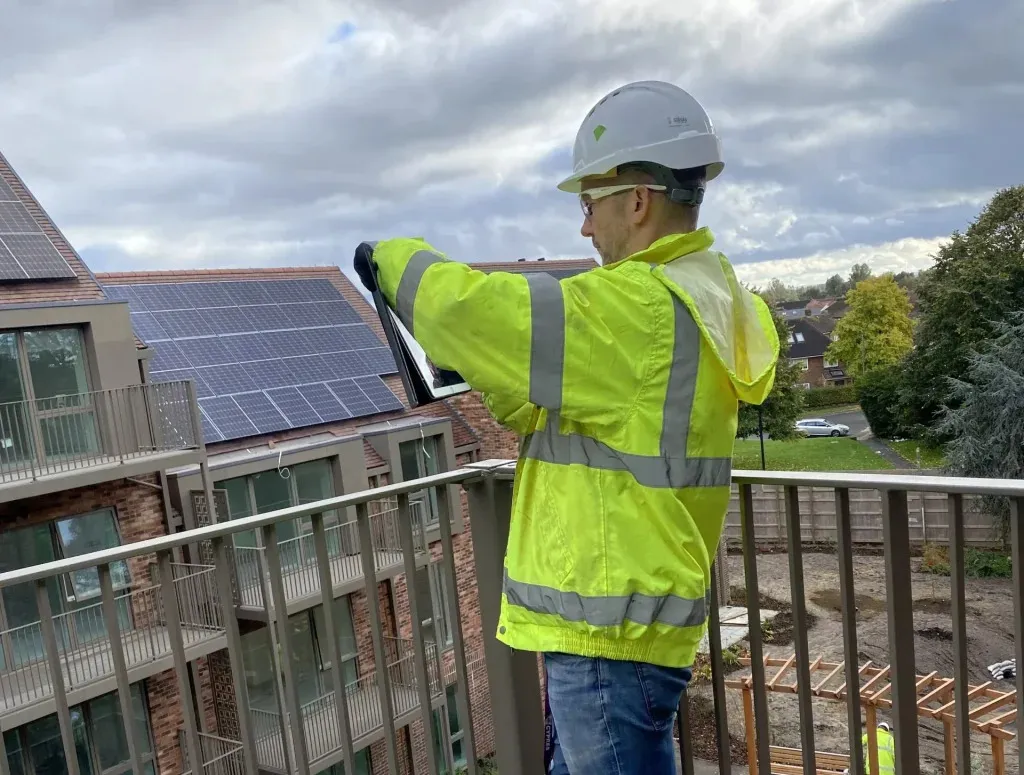 John Slaney of EcoSkye inspecting a solar panel roof on a new apartment development